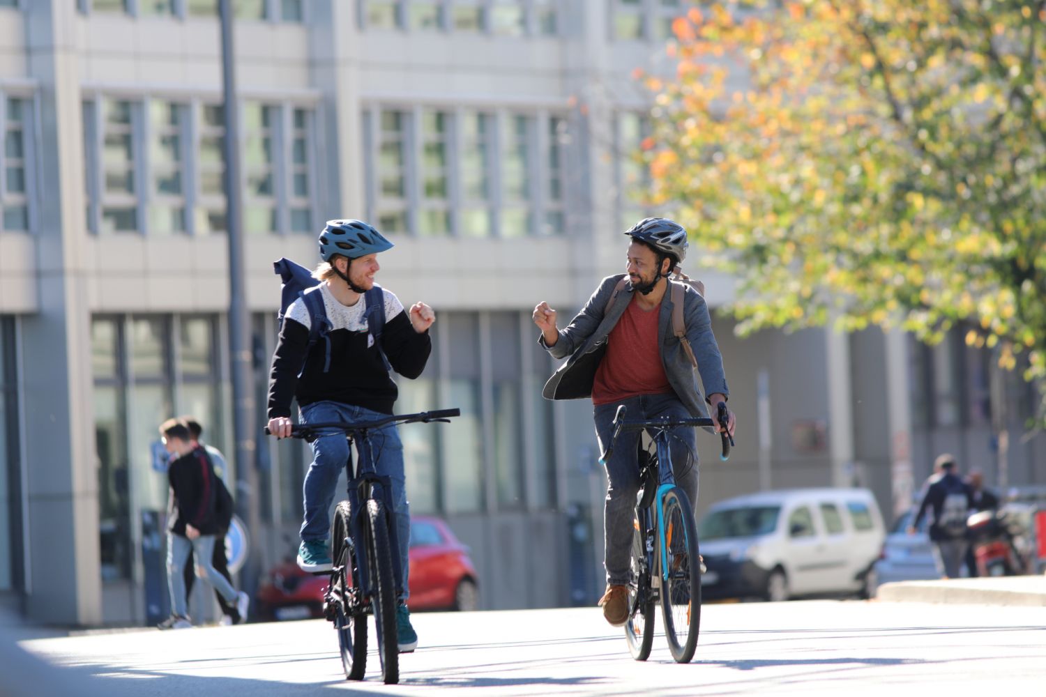 Zwei Fahrradfahrer in der Stadt unterhalten sich während sie fahren