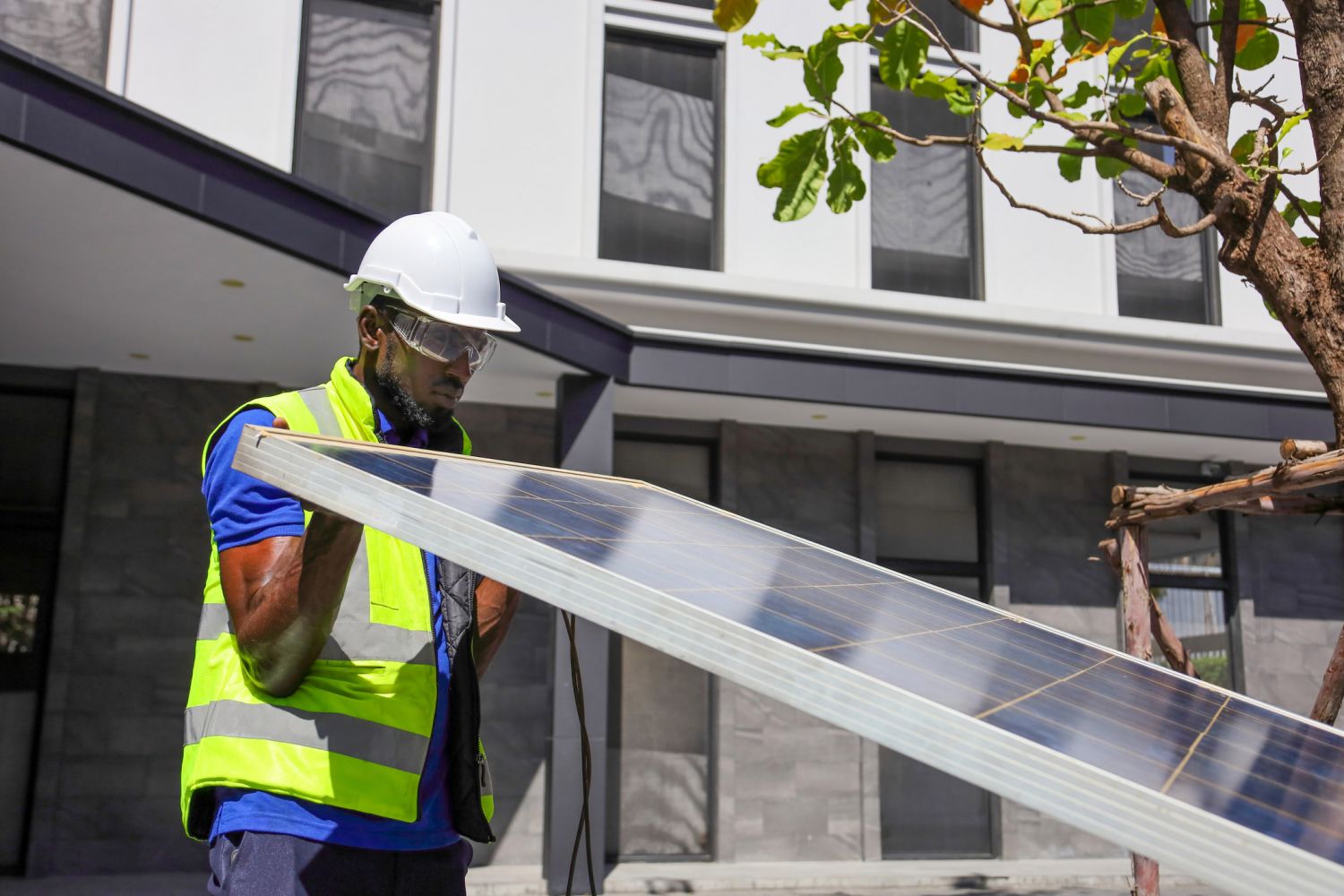 Ein Bauarbeiter stemmt eine Solarplatte.