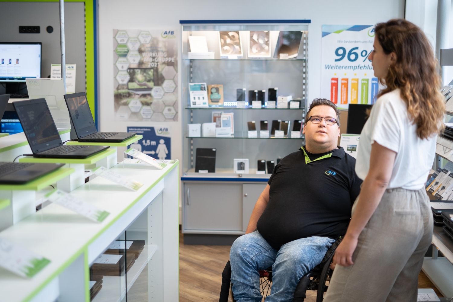 Verkäufer von AfB im Rollstuhl führt Gespräch mit Kundin